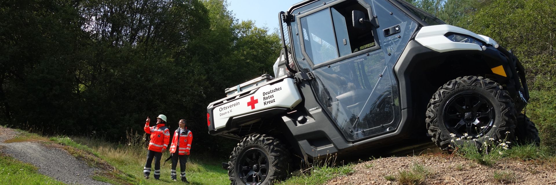 Foto: ATV steht am Hang, Helfer im Hintergrund beraten sich.