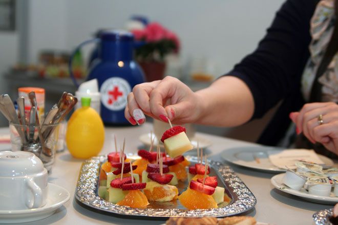 Foto: An einem gedeckten Tisch bedient sich eine DRK-Spenderin nach der Blutentnahme an den Obstspießen.